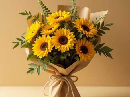 Handcrafted sunflower bouquet wrapped in kraft paper and rustic rope, styled with fresh greenery in warm natural lighting