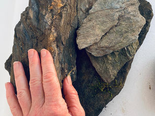 Eine Hand berührt einige Stücke Glimmerschiefer der Pernegg Gruppe