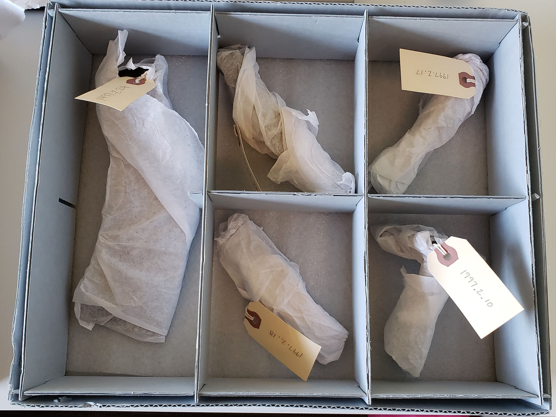 Object wrapped in acid-free tissue, put into tray, and ready to be loaded into an acid-free cardboard box. box.