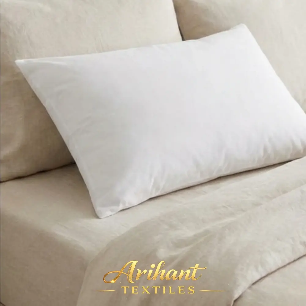 Standard size plain white fiber-filled pillow manufactured by Arihant Textiles for wholesale supply.