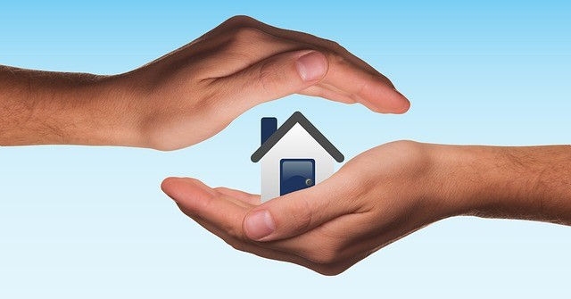 Two hands cupping an image of a house