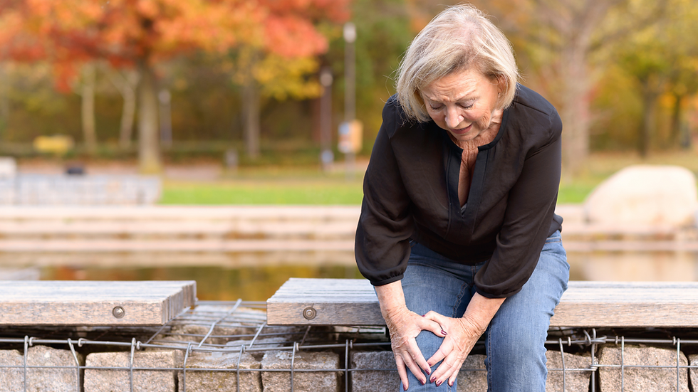 older woman sitting, holding knee showing pain from osteoarthritis