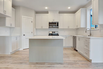 Contemporary open-plan kitchen with clean lines, stainless steel appliances, and a minimalist design.