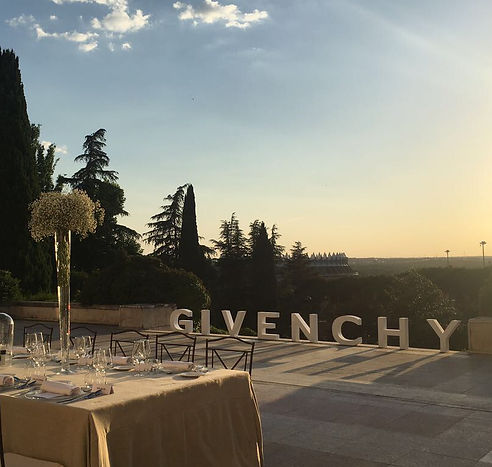 Givenchy outdoor event at sunset with tables set up, capturing the serene atmosphere of the venue.