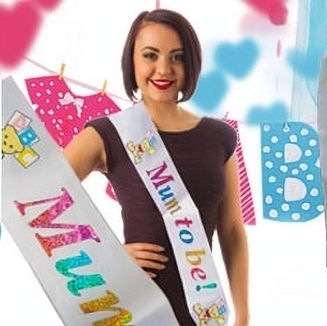 Smiling woman wears a sash that says Mum to be! at the party