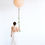Thumbnail: Woman holding a large balloon with floral garland, white dress, and background.