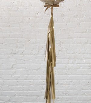 Thumbnail: Gold tassel decoration against a white brick wall background for party decor.