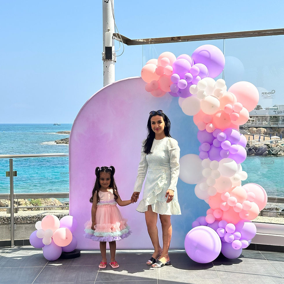 Thumbnail: Mother and daughter pose with balloons near the ocean; Personalized Pumpkin Balloon Stack.