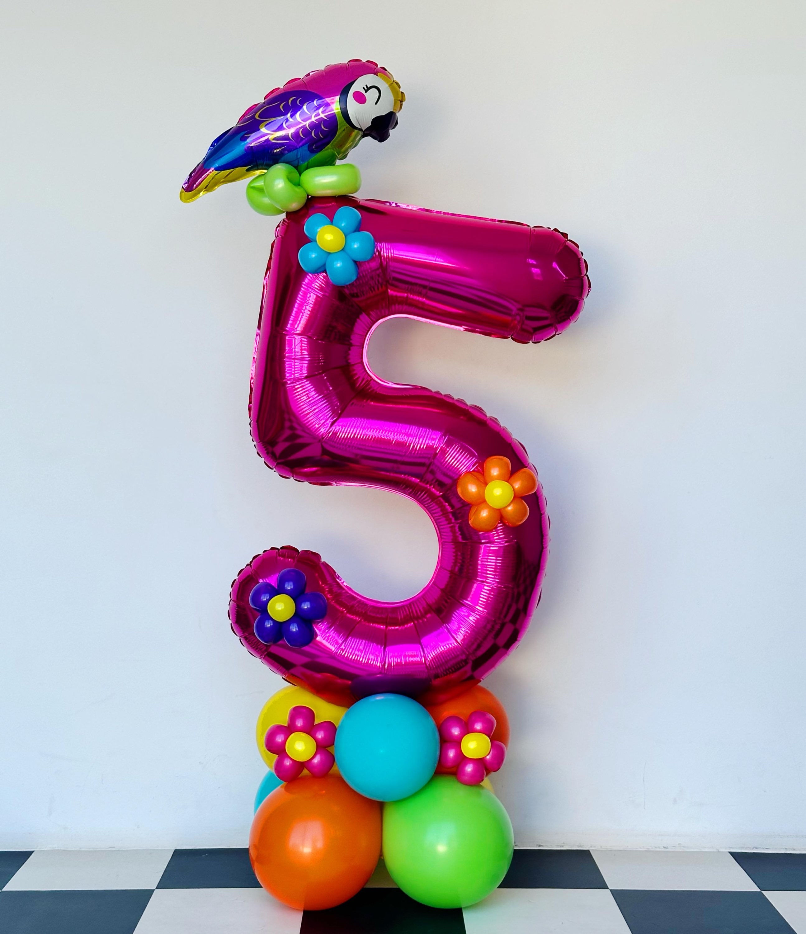 Pink number 5 balloon with parrot topper and flower accents, colorful party decor.