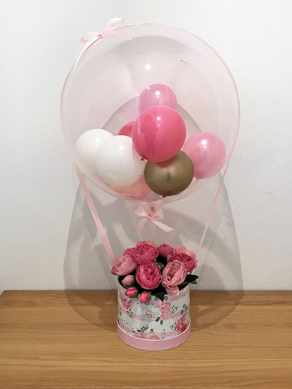 Thumbnail: Pink balloons in a clear bubble with flowers in a gift box