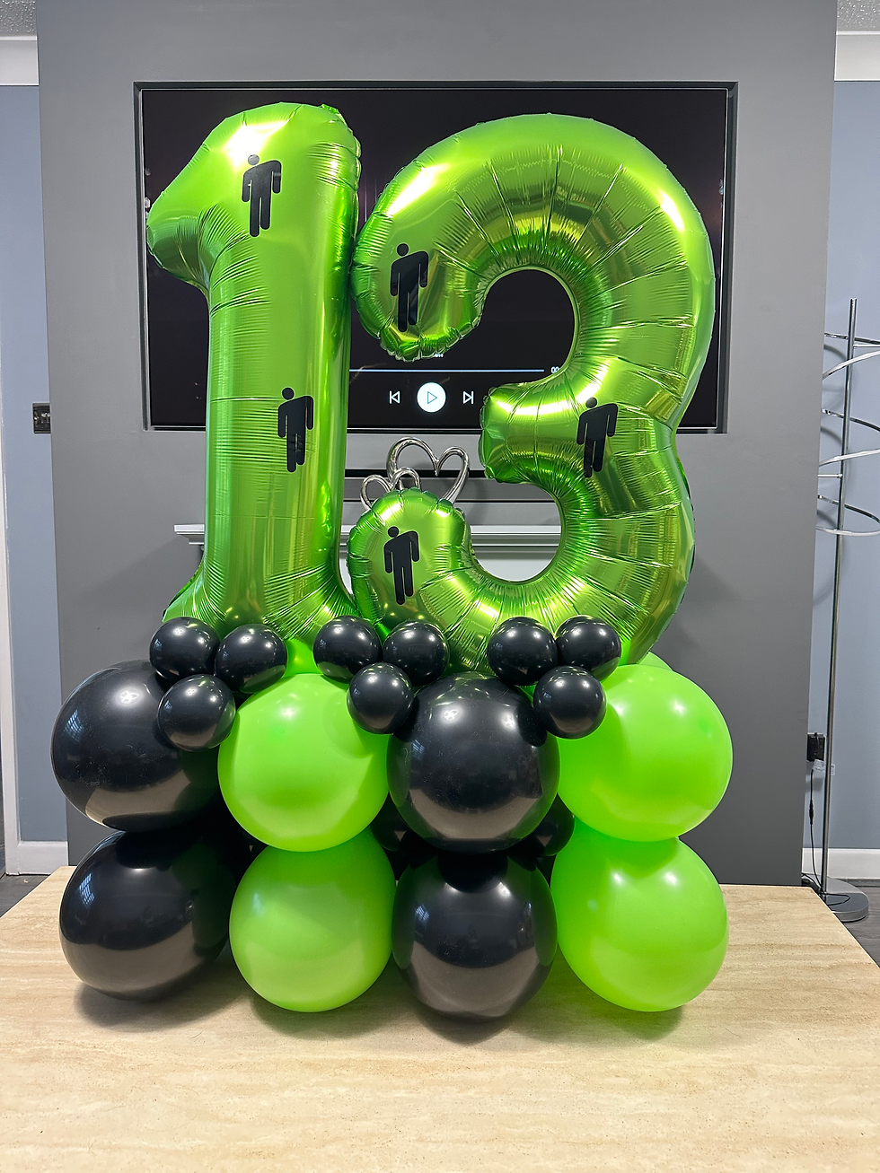 Green 13 balloon arrangement with black balloons and Billie Eilish logo.