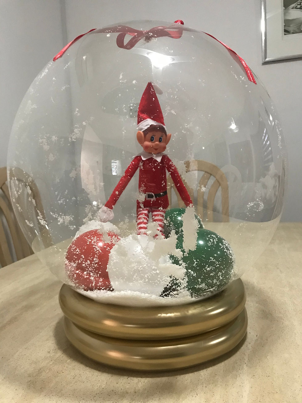 Thumbnail: Elf figurine inside a snow globe with red and green accents on stand.