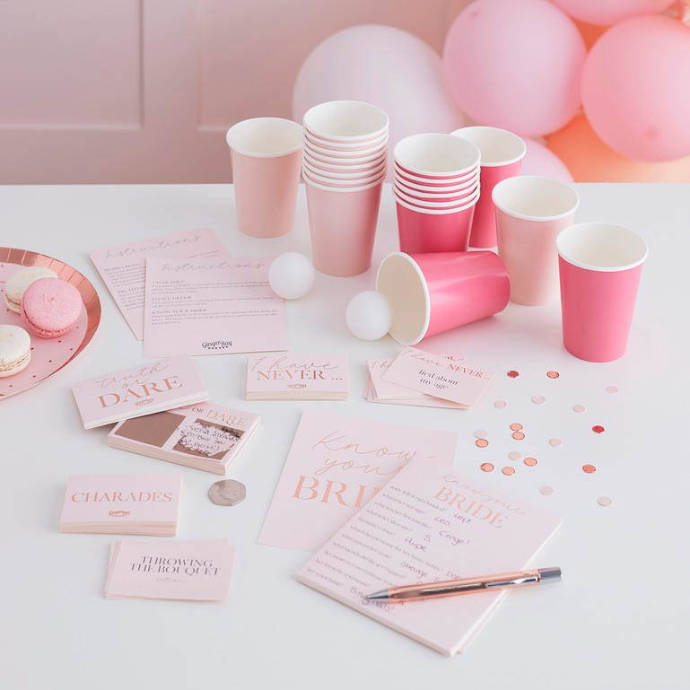 Thumbnail: Pink party decorations with glasses, cards, and Know Your Bride game on display.
