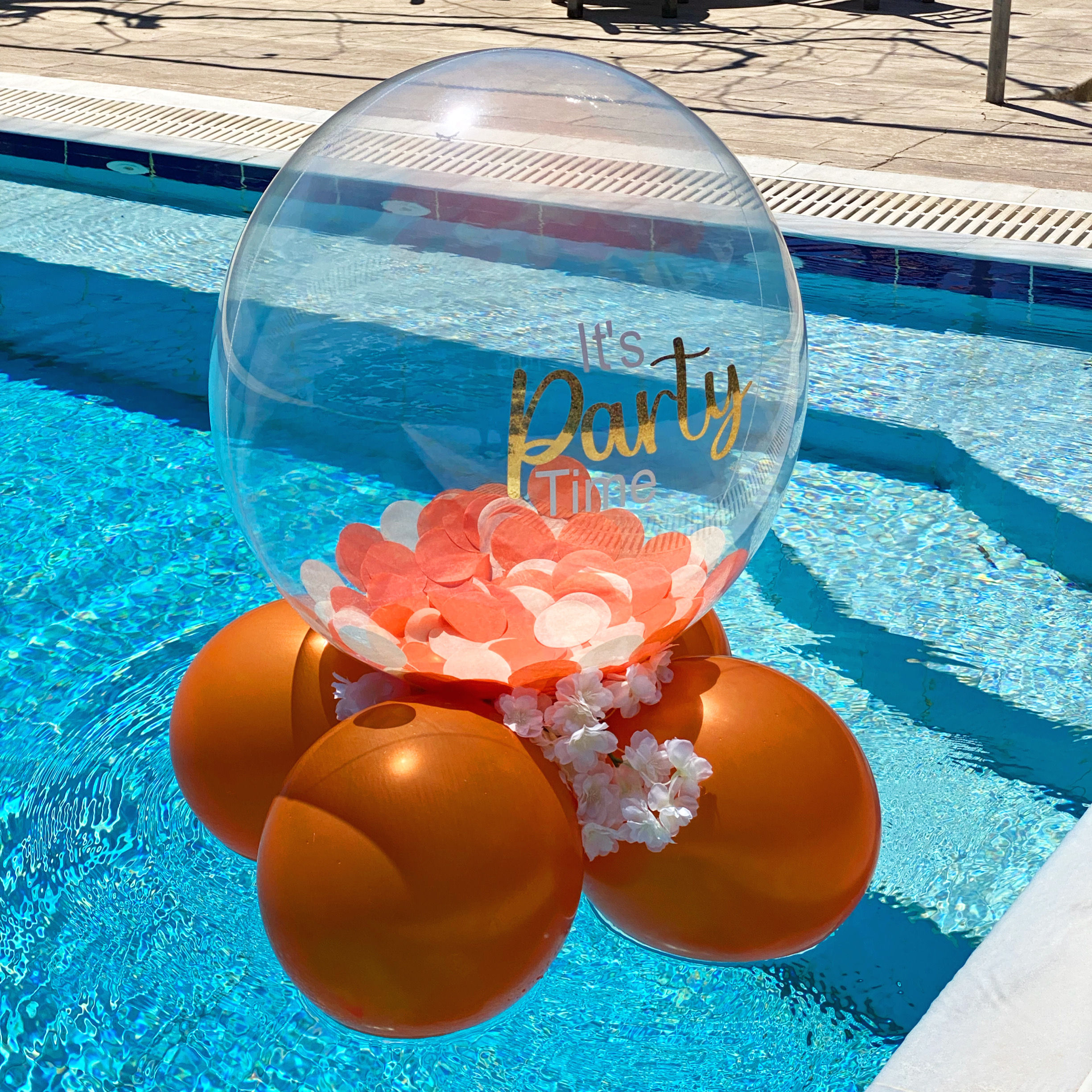 Orange balloons float with a transparent balloon; it's party time. Party World Ferndown