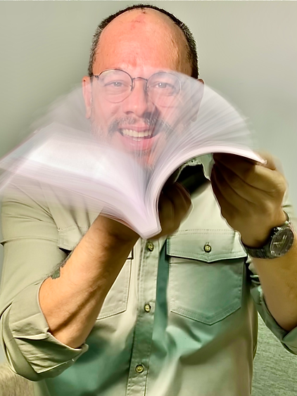 Foto do Psicólogo Alberto Maia segurando um livro aberto diante do seu rosto enquanto faz passar as páginas