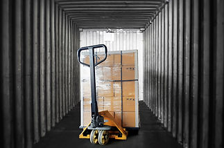 Inside view of shipping container. Cargo shipment boxes stacked on pallet with hand pallet