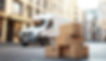 delivery-van-parked-beside-stacked-cardboard-boxes-on-urban-street-free-photo.jpg