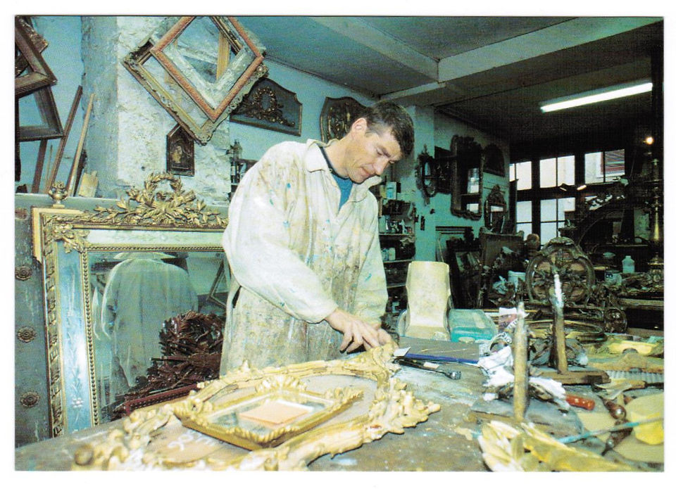 Carte postale avec une photographie de David Jousselin, doreur sur bois à Bayonne (Pyrénées-Atlantiques) en train de restaurer un miroir ancien, août 2000. Archivage atelier Or Cadre, Laetitia Nicolas, Lodève.
