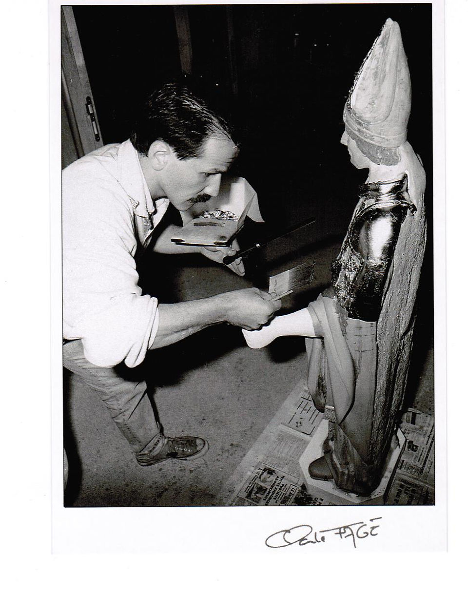 Déroulement d'un travail de restauration en dorure d'une statue de Saint Clair par Bertrand Lotteau, qui après différents stages (8 ans de formation) chez des Maîtres Doreurs-Laqueurs, s'est installé en 1989 à Vaux en Pré en Saône-et-Loire.  La quatrième phase est la pose des feuilles d'or. Photographie de Claude Fagé, 1992. Archivage atelier Or Cadre, Laetitia Nicolas, Lodève.