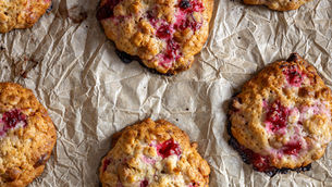 A close-up of the baked redcurrant and oat Cookies on the crumpled baking paper.