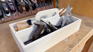 Handmade wooden toolbox filled with woodworking hand tools in the Nova Labs woodshop.
