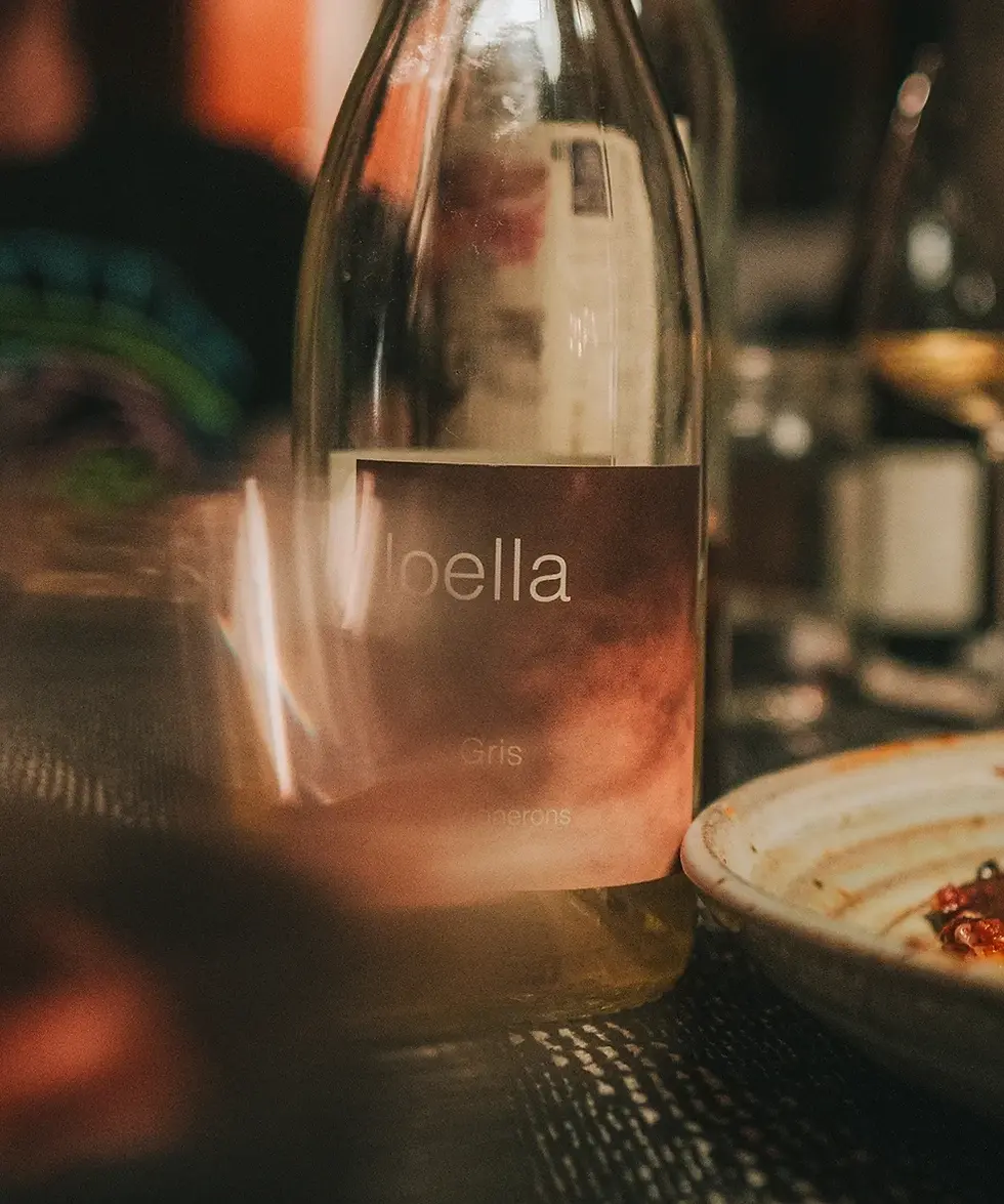 a bottle of wine of loella wine on a table at an intimate dinner party