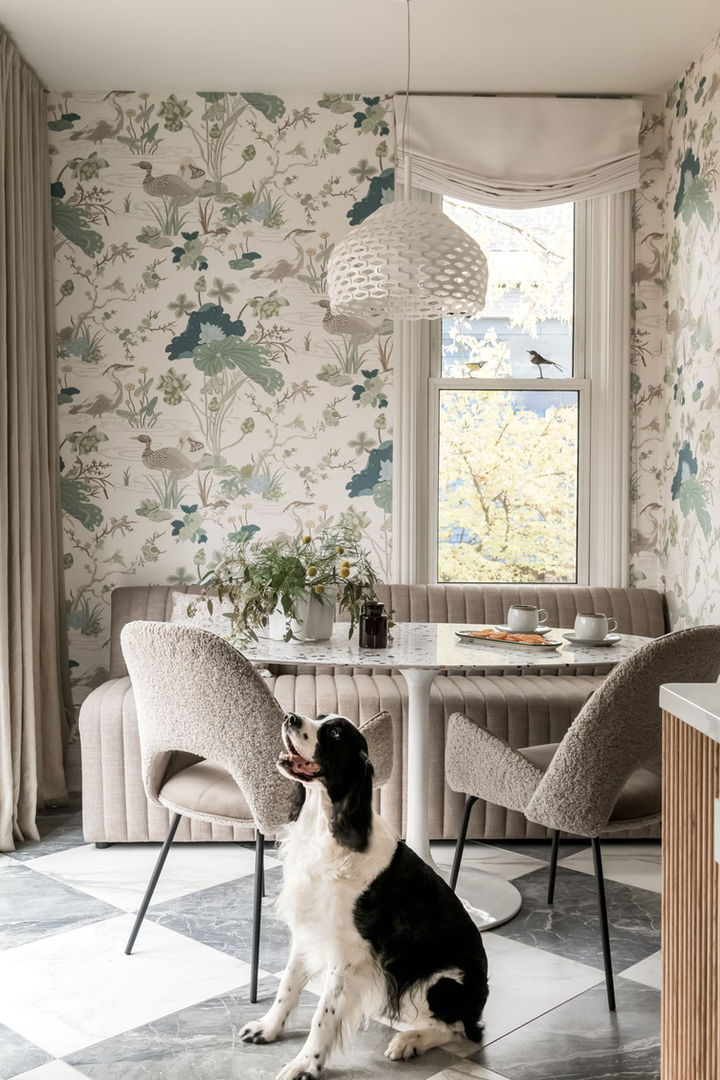 Breakfast nook with botanical wallpaper and upholstered banquette in Victorian farmhouse kitchen remodel.