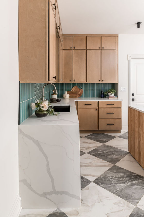 Modern shaker kitchen corner with green tile backsplash and marble checkerboard floor.