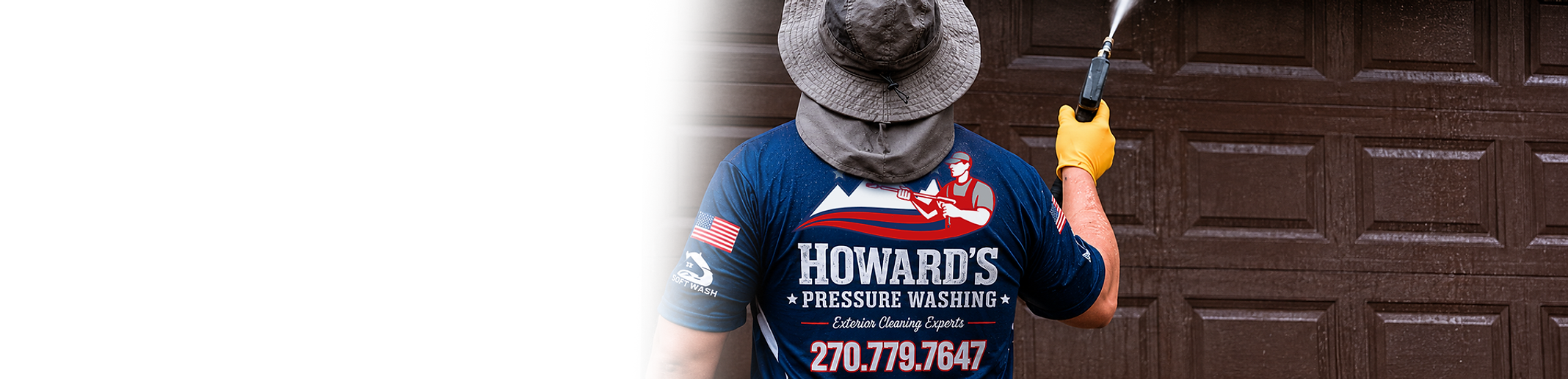 Professional pressure washing technician cleaning a residential garage door in Bowling Green KY