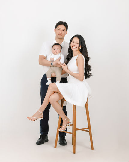 Studio portrait of 100-day-old baby held by mother and father, captured at Cheesedal Studio