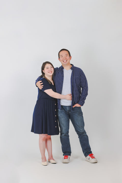 A couple standing side by side in a studio, smiling gently against a white backdrop.
흰 배경 앞에서 나란히 서서 은은하게 웃고 있는 부부의 스튜디오 사진