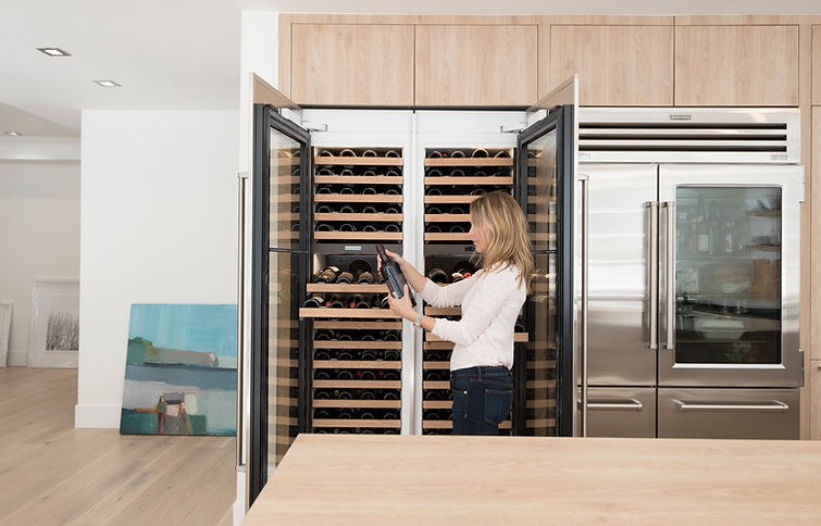 Leicht client in front of Subzero wine chillers and refrigerator. Bondi and Synthia door fronts.