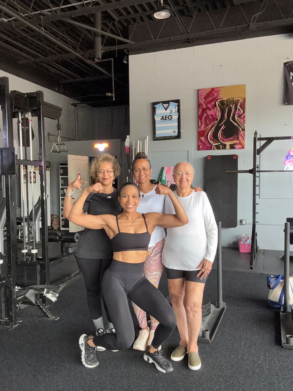 Certified personal trainer posing with clients in the gym