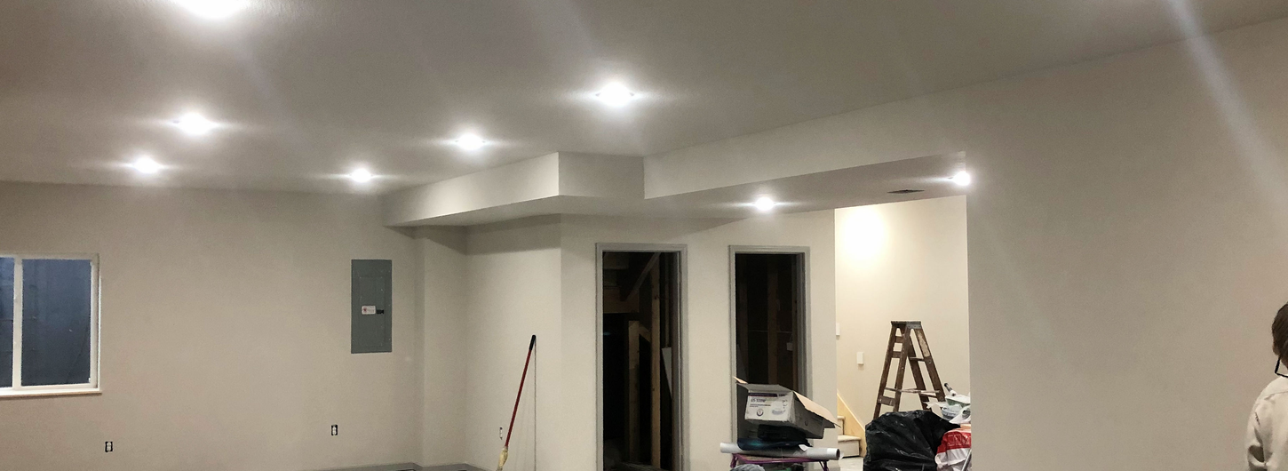 Basement interior painting and flooring stage with painted walls, recessed lighting, and new flooring during final remodel by (BDS) Brian's Drywall Services in Lee's Summit MO
