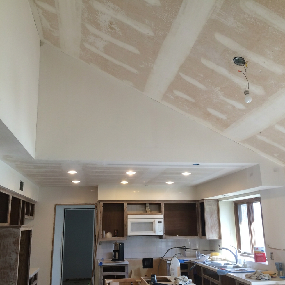 Popcorn ceiling removal and drywall repair by Brian’s Drywall Services in Blue Springs, MO (Kansas City metro) – professional scraping, joint compound patching, and smoothing on vaulted ceiling with recessed lighting in residential kitchen remodel.