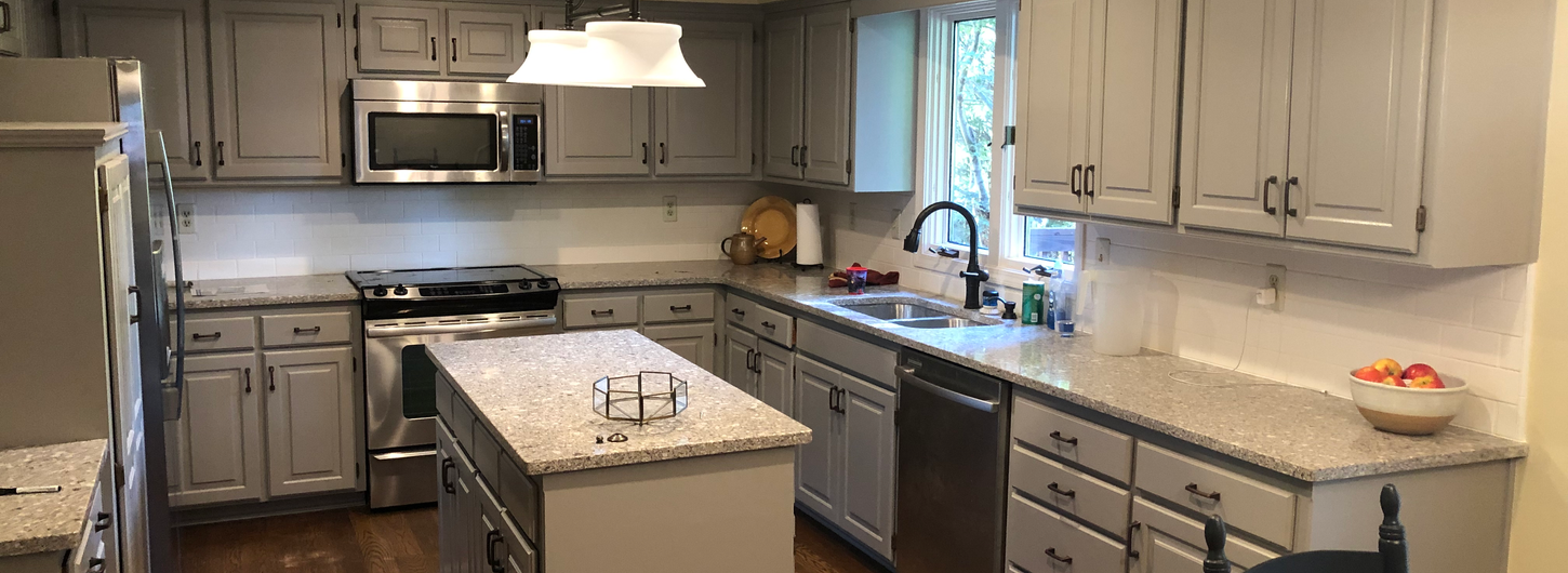 Beautiful painted kitchen cabinets, fully transformed light gray painted cabinets with granite countertops, kitchen island, and updated interior in this stunning home remodeling result by (BDS) Brian's Drywall Services in Leawood, KS