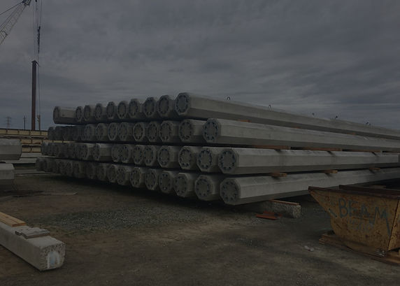 Precast octagonal concrete piles stacked on supports in a storage yard
