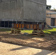 Raised concrete structure supported on temporary cribbing at a construction site