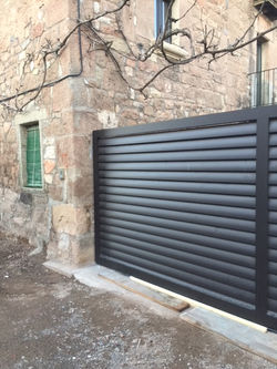 Porta corredera de lames d'alumini