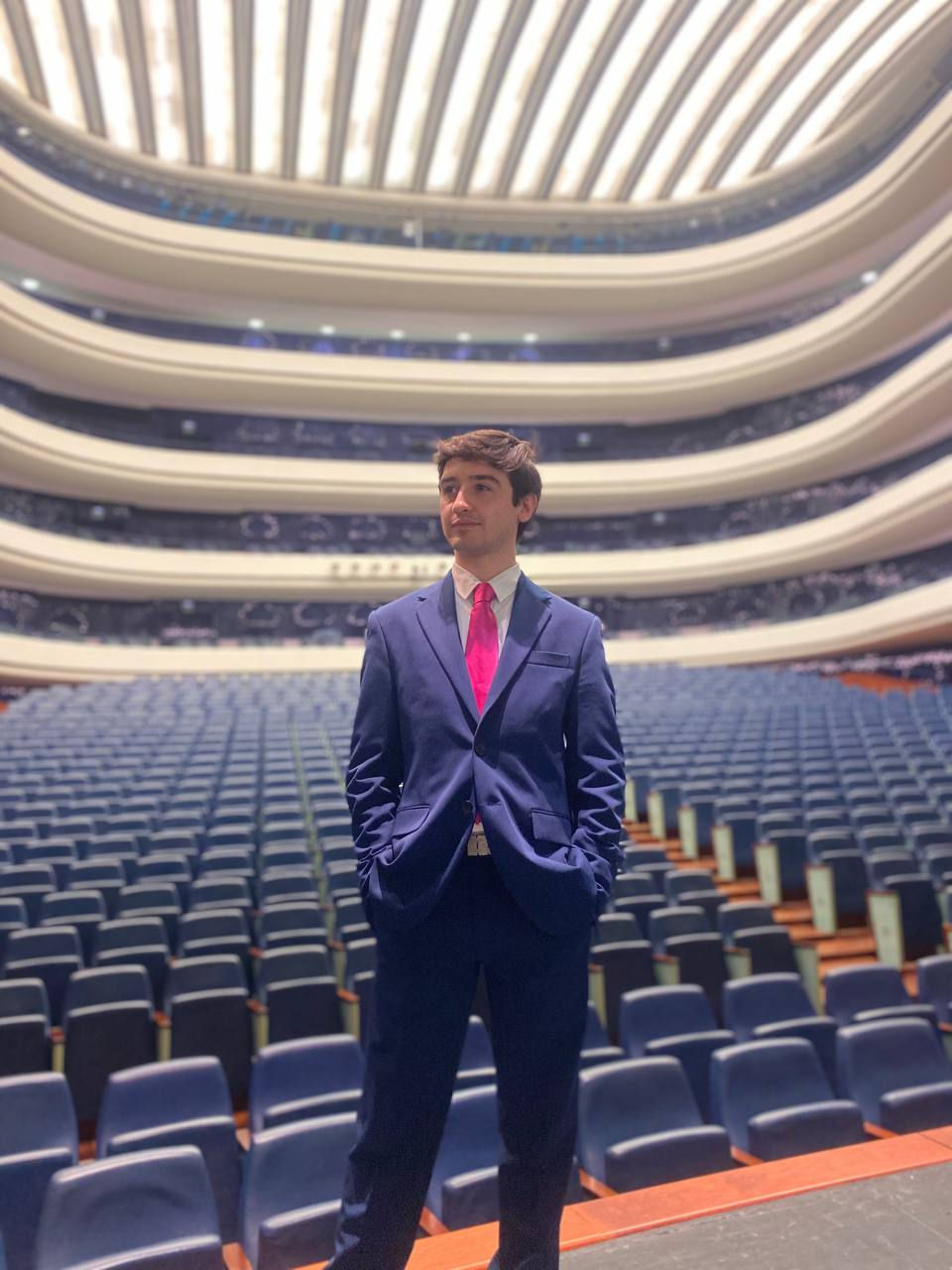 Maximiliano Spósito, tenor, um jovem de fato e gravata num anfiteatro