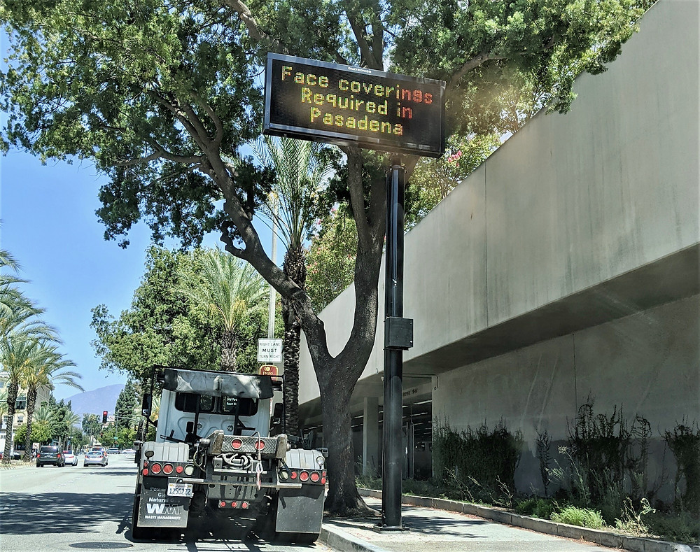 Street sign saying "Face coverings Required in Pasadena"
