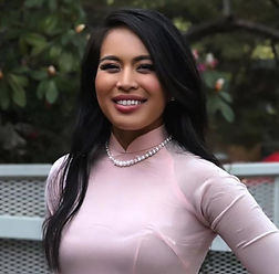 A woman with dark hair and a pink dress.
