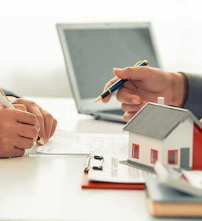 Filling out forms with a scale model of a house in the foreground