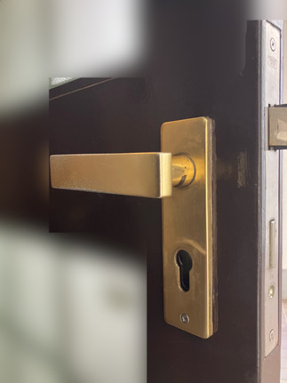 鍵交換の為に部品が取り外された状態の鍵穴とドアレバー