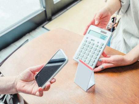 卓上の電卓で料金提示をする店員と客