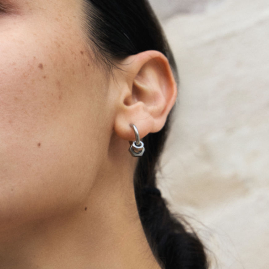 Lucky Ohrringe – vergoldete Kreolen mit zwei Muttern am Ohr getragen, feines industrielles Detail