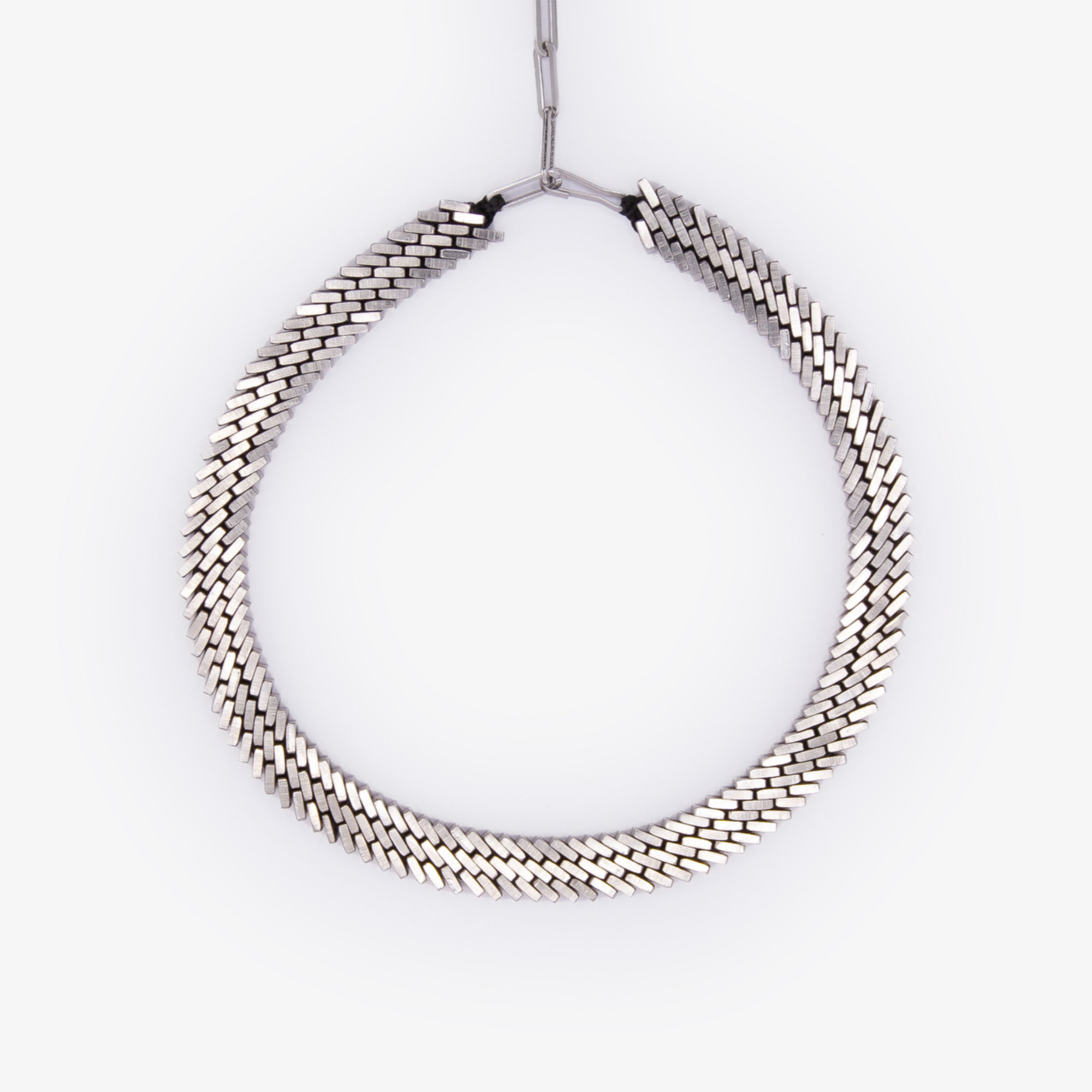 Bold Kette aus Edelstahlmuttern – gleichmäßige, skulpturale Form auf hellem Hintergrund