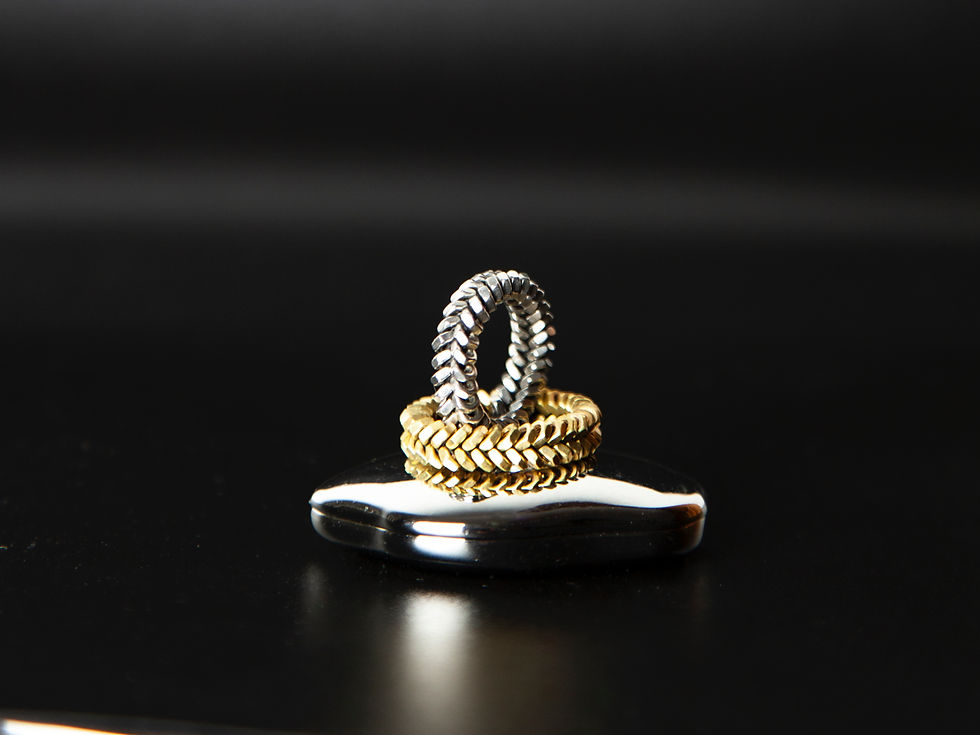 Everyday Ringe aus Edelstahl- und Messingmuttern gestapelt– industrielle Schmuckform im Stillleben