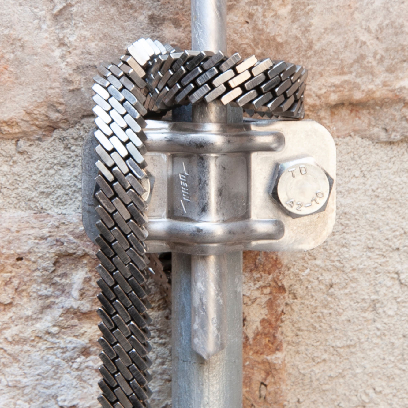 Bold Kette aus Edelstahlmuttern – industrielle Struktur an Metallobjekt inszeniert