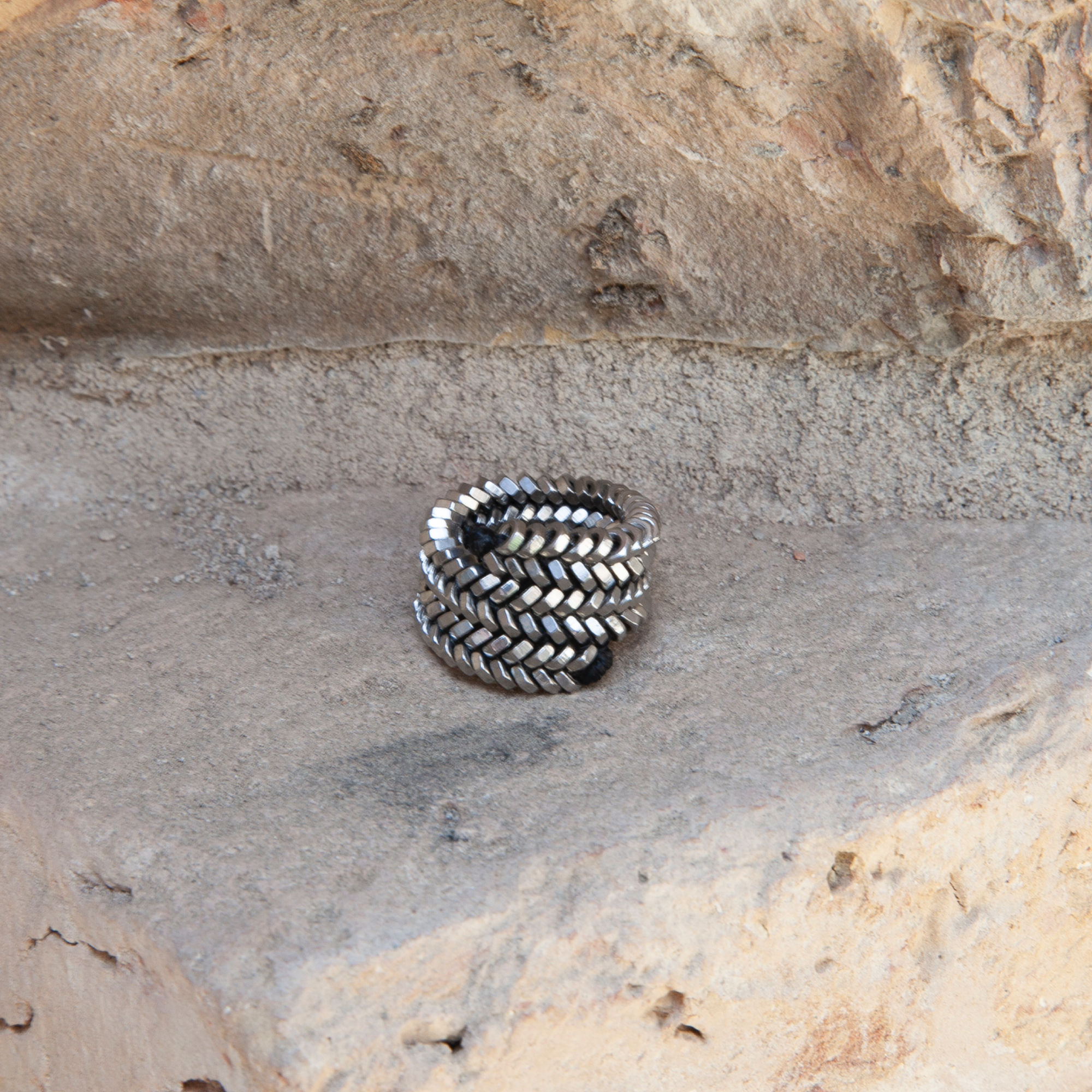 Bond Ring aus Edelstahlmuttern auf Stein – industrielle Struktur trifft auf natürliche Oberfläche